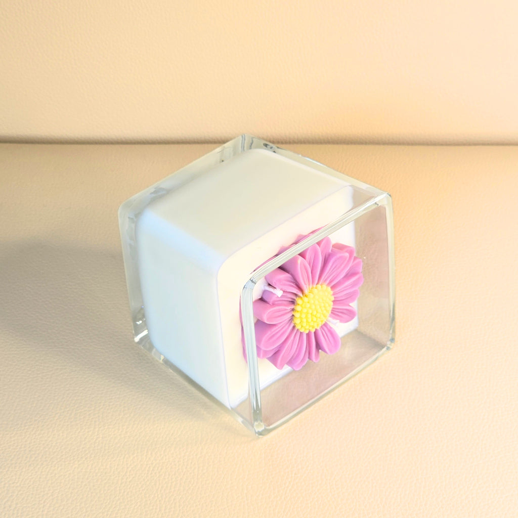 Side view showing sculpted pink flower on creamy white soy wax.