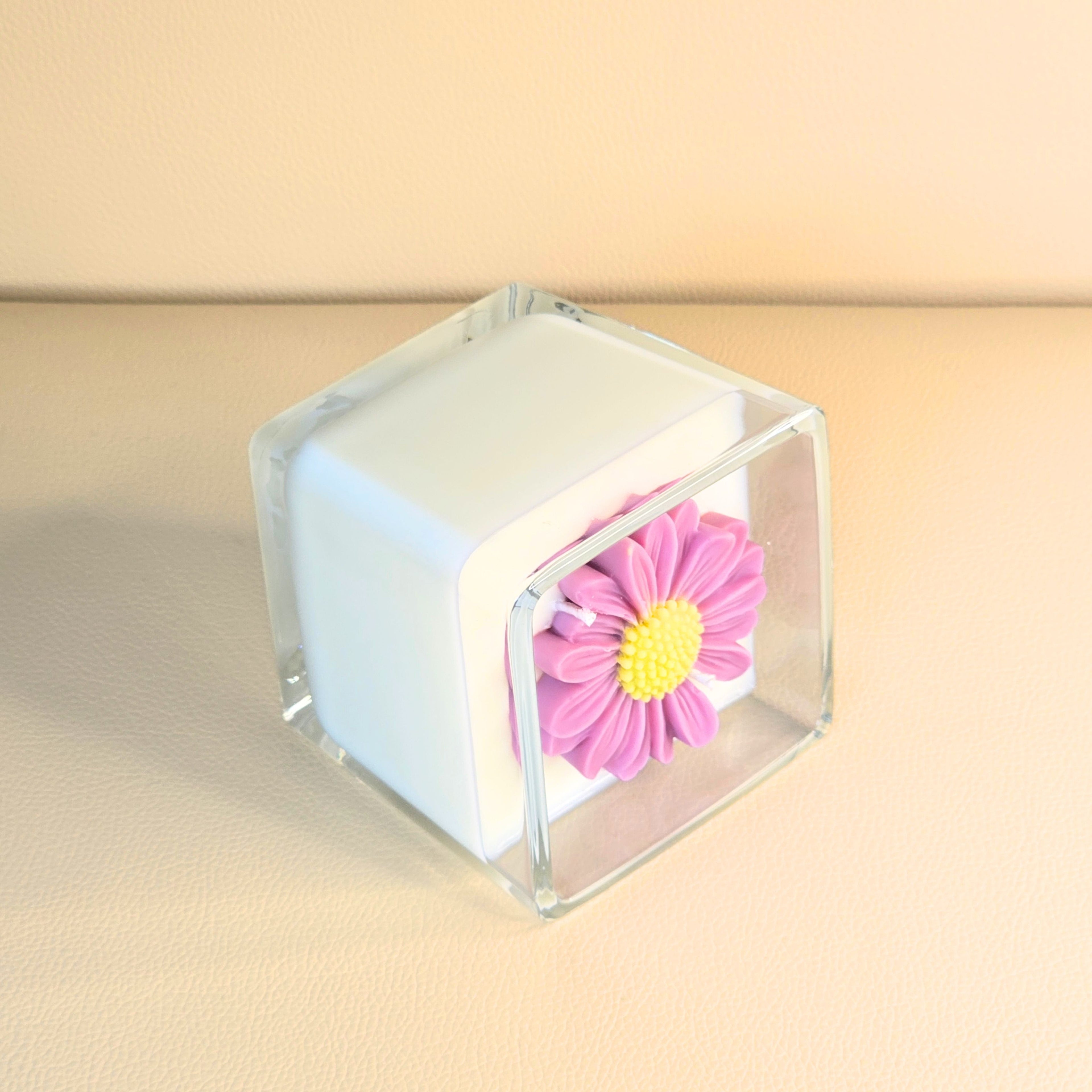 Side view showing sculpted pink flower on creamy white soy wax.
