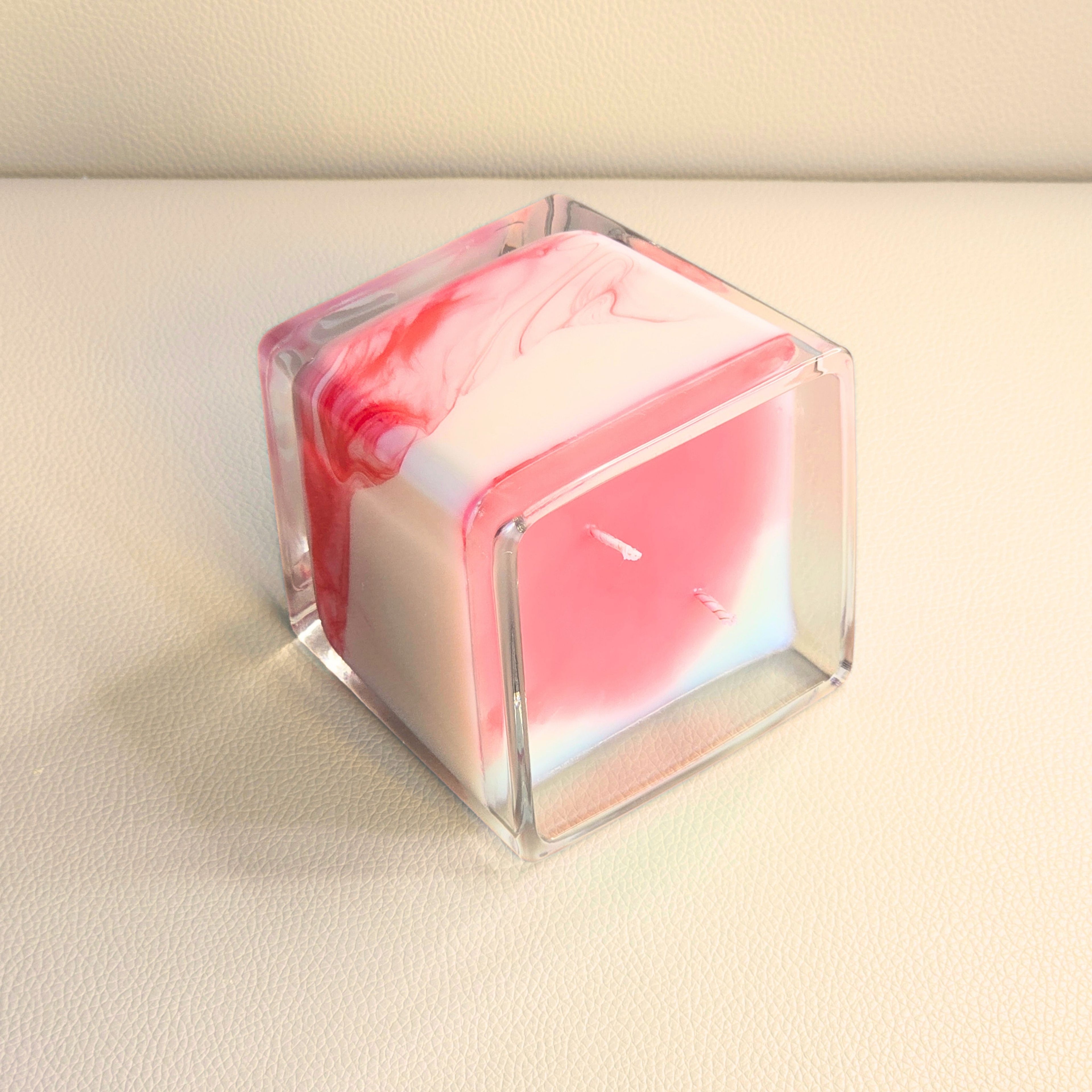 Passion Storm candle lying on its side revealing fluid red wax patterns