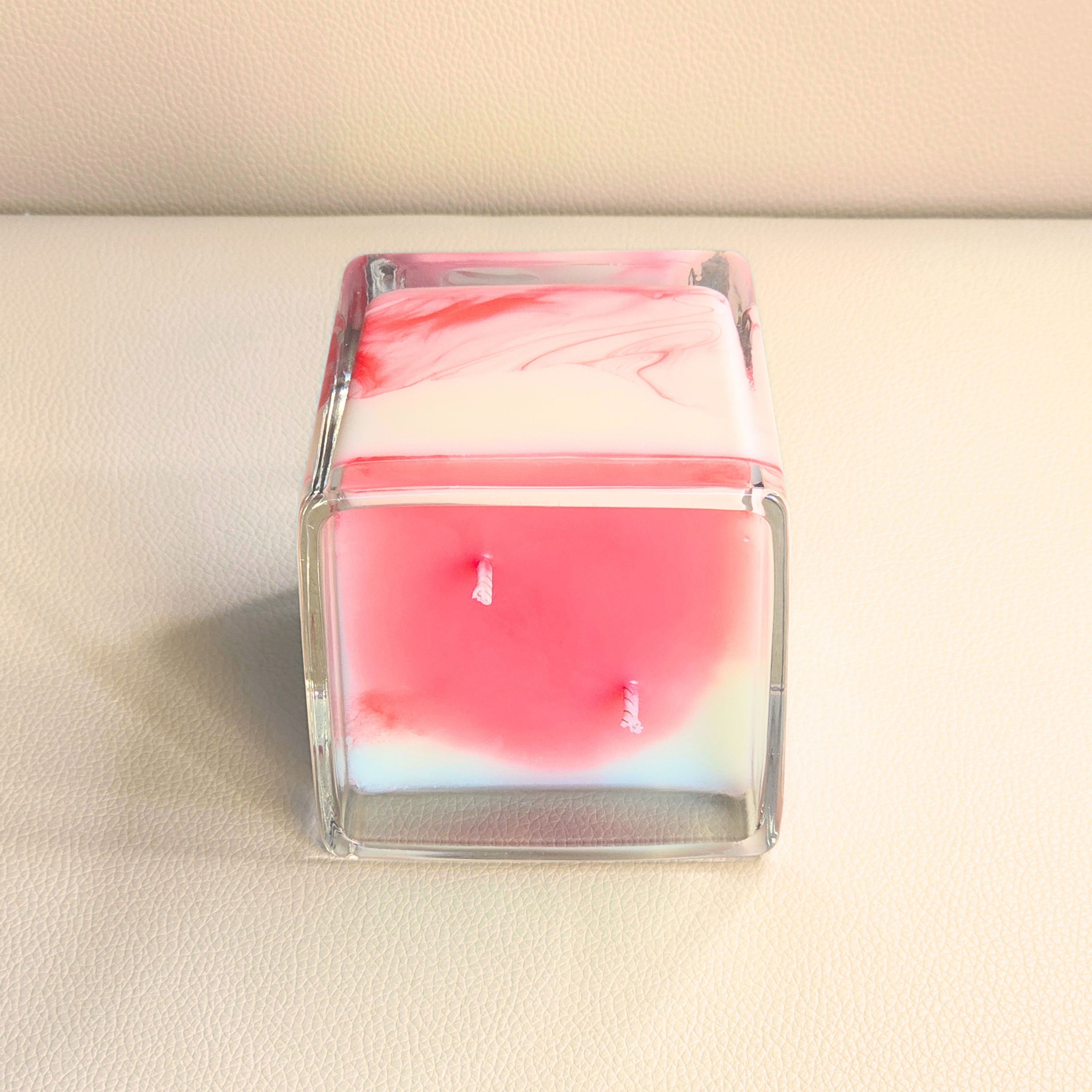Close up of the Passion Storm candle showing its vibrant red top and natural swirl details